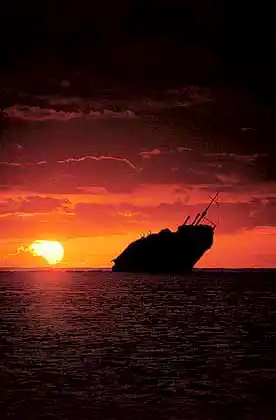 Shipwreck of the Runic on Middleton Reef, Coral Sea, at sunset.