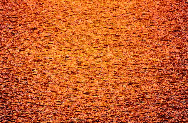 Sunset glow on ocean surface.
